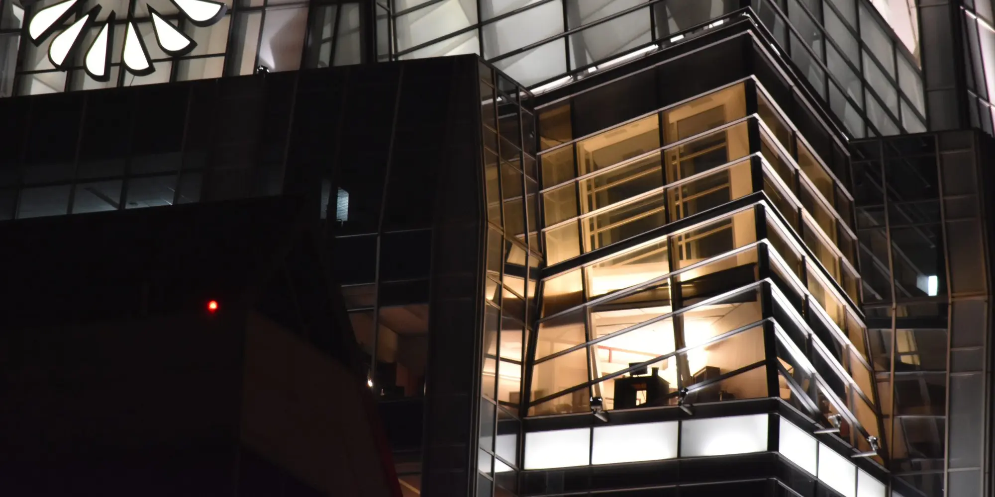 Glass corner office lit up at night